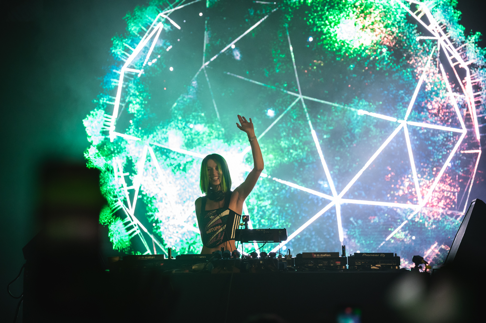 DJ with geometric green visuals